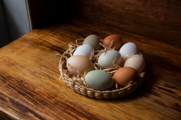 Canasta de huevos frescos de granja orgánicos libre pastoreo varios colores ordenados vistos desde arriba inclusión razas