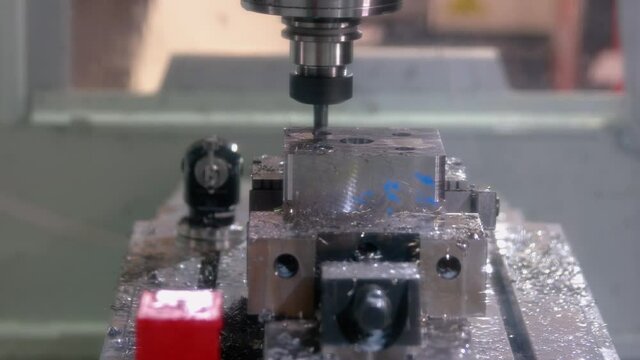 Close-up drill bit machine lathing a metal element.