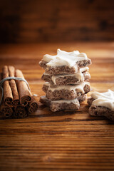 Stack of homemade cinnamon stars on brown vintage wood. Vertical close up of gingerbread cookies. Winter and christmas background with space for text.