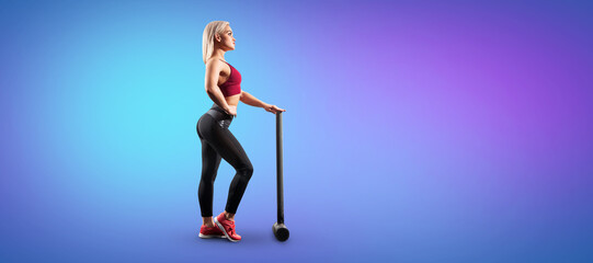 Sexy fitness woman is posing with the sledgehammer.