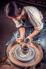 Hands of the master potter and vase of clay on the potter's wheel close-up. Master crock. Twisted potter's wheel.