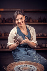Pottery master demonstrates the finished clay product in a pottery workshop. Handcraft.
