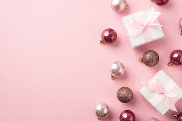 Top view photo of pink christmas decorations balls and white gift boxes with pink ribbon bows on isolated pastel pink background with blank space