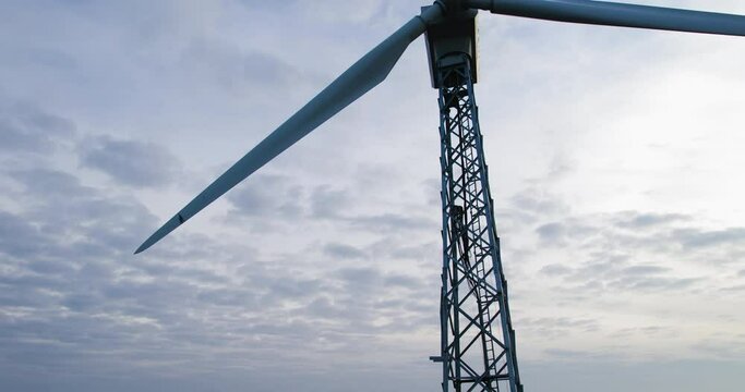 AERIAL VIEW: wind turbine with a fixed propeller in the countryside. Quiet windless weather on a picturesque foggy morning. Slow movement of the drone from the bottom up. Concept of alternative energy