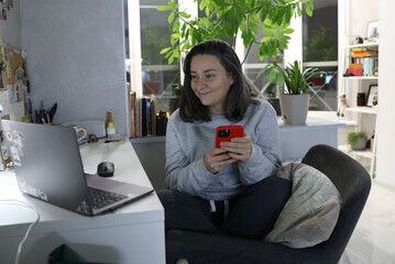 Adult woman working at home at the computer in home clothes