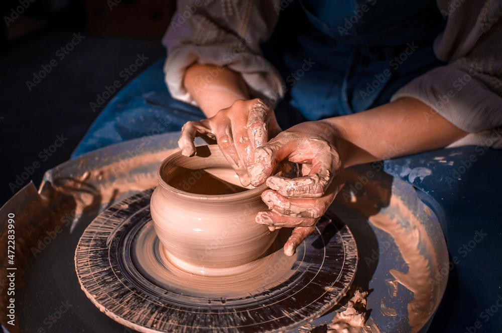 Wall mural Craftsman master making ceramic pottery on wheel. Making ceramic dishes. Close-up.