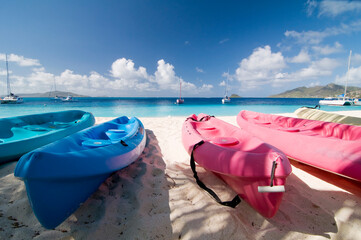 Colorful kayaks on tropical sandy beach. Boats for rafting on water. White sand, turquoise ocean...