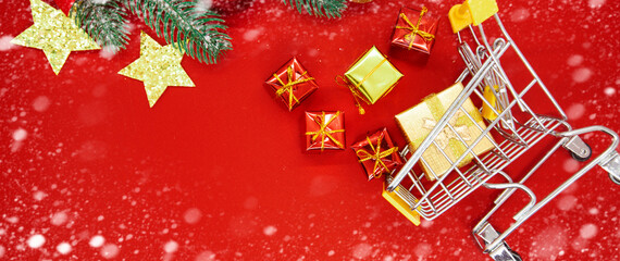 christmas background with decorations, shopping cart on red background, copy space. 