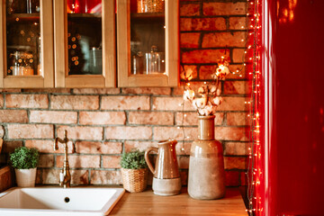 kitchen in authentic stylish chalet decorated for Christmas or New Year eve dinner, details of a cozy kitchen interior with a brick wall
