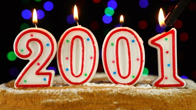 Birthday cake with white burning candles in the form of number 2001