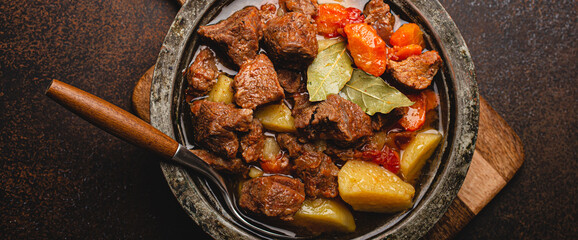 Macro close-up of delicious beef meat stew dish with meat cubes, potatoes, carrot and gravy in...