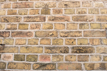 Old yellow and dirty brick street wall