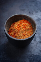 Traditional fine grinded rub for barbecue pulled beef and pork offered as close-up in a rustic bowl...