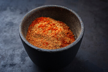 Traditional fine grinded rub for barbecue pulled beef and pork offered as close-up in a rustic bowl...