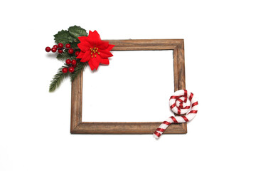 Photo frame surrounded by poinsettia flowers, canes and pinwheels as a Christmas prayer for a Christmas message

