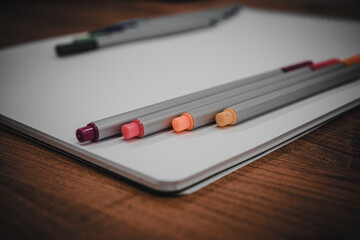 colored pencils on sketchbook on wooden table in school