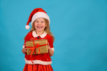 Happy merry Christmas child in Santa hat hold gift. beautiful girl smiles laughs. Congratulate celebration. Jolly Santa Claus preparing box gold red bow. Happy New Year. Place for text. Copy space. 