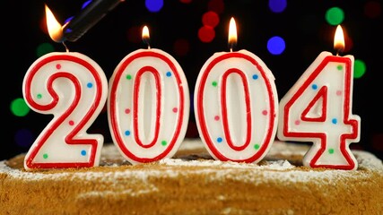 Birthday cake with white burning candles in the form of number 2004