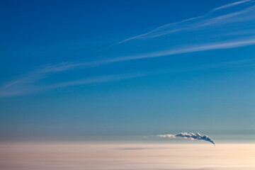Smoke from pipe above the clouds, air photo