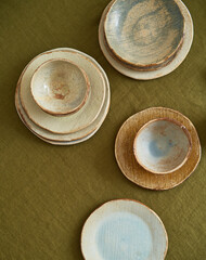 Modern dining table setting. Only natural materials - earthenware, linen textiles, dried flowers. Top view.