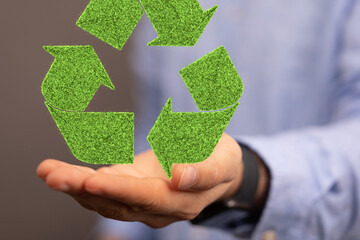 hand holding green recycle symbol