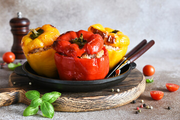 Stuffed pepper. Paprika with rice and minced meat. Baked peppers in a cast iron pan on a concrete background. Dinner