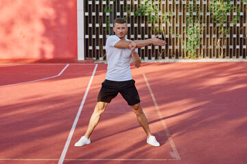 Obraz premium man in white t-shirt on the sports ground workout motivation