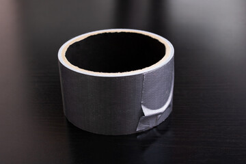 Spool of gray scotch tape on wooden background