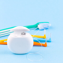 Dental floss, toothbrush and interdental brush angles on blue background, square format