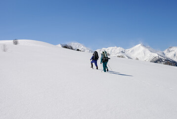 Fototapeta na wymiar tourists with backpacks climb the snow uphill