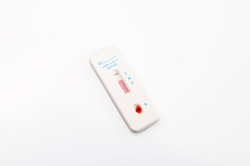 isolated shot of a rapid express antigen antibody coronavirus covid-19 pandemic test sample with blood on white background