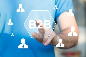 Businessman presses button b2b on network. Business to Business concept.