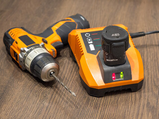 cordless drill .screwdriver, drill, charger and battery on boards