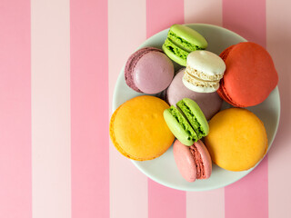 Fresh baked colored macaroon cookies macarons, macarons on a white plate close-up,