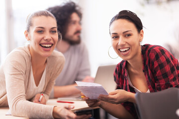 Students listening to a lecturer in a classroom. Smart young girls talking smiling and giving advice to each other.