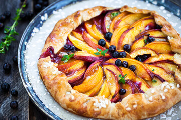 Rustic open pie (galette) with peach and berry