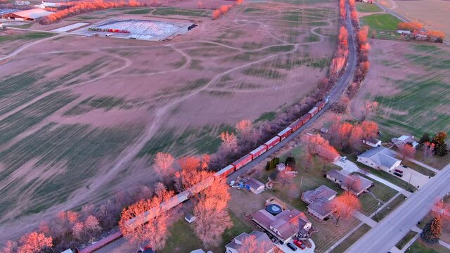 The Sun's first rays illuminate a freight train as it speeds across the rural landscape, leaving Wrightstown bound for Green Bay, Wisconsin.