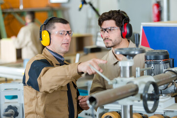 metal craftsman teaching know-how to young man