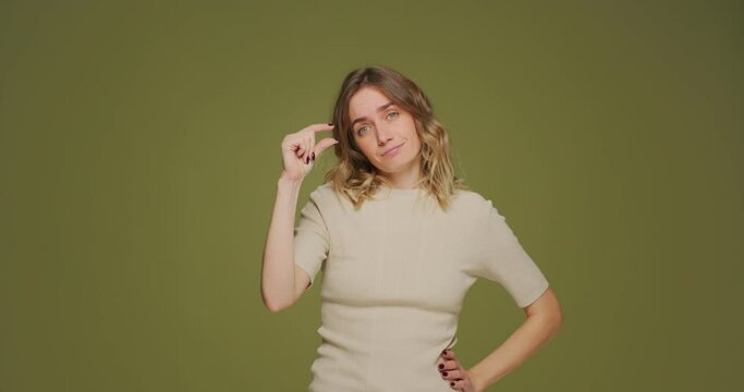 Woman make little size gesture, demonstrate tiny object, shrug shoulders spread hands. Body language, hand sign concept 