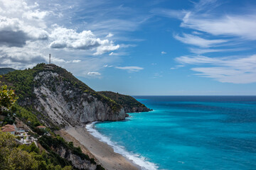 Fototapeta premium Mylos sandy beach with azure vibrant stormy waves on coast of Lefkada island in Greece. Summer nature vacation travel to Ionian Sea