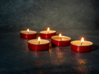 Small candles burn orange in the dark.  Waiting for the holiday
