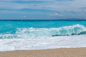 Azure vibrant breaker waves hitting shore. Sunny coast of Greek island with blue sky. Sandy beach in Greece. Summer nature travel to Ionian Sea