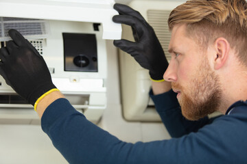professional repair service man installing a clean new air filter