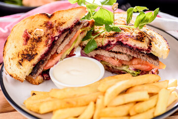 A serving of Steak Sandwich with French Fries and dipping sauce