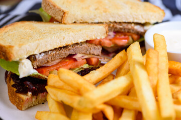 A serving of Steak Sandwich with French Fries and dipping sauce