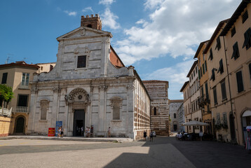 Fototapeta na wymiar Lucca, Tuscany, Italy. August 2020. The facade of the church of Santi Giovanni e Reparata on a beautiful sunny day. People in the square.