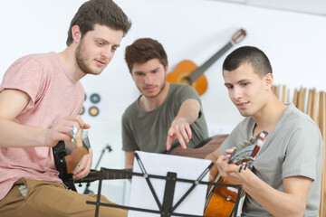 three teenagers playing music at home
