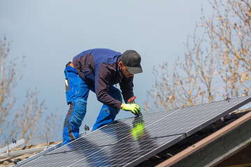 Installing solar photovoltaic panel system. Solar panel technician installing solar panels on roof....
