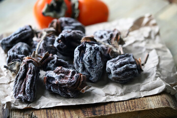 Selective focus. Macro. Dried persimmon on a wooden surface.