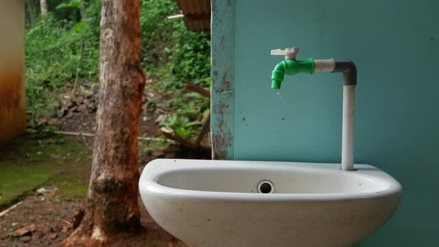 4k footage of a leaking faucet that keeps dripping water. water waste